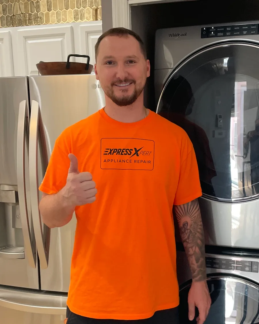 Dmitriy Sukhov, founder of Express Xpert Appliance Repair, beside a stacked washer and dryer in a customer's laundry room